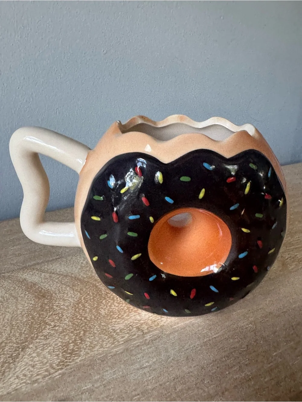 Donut-Shaped Ceramic Mug with Black Frosting and Tan Body